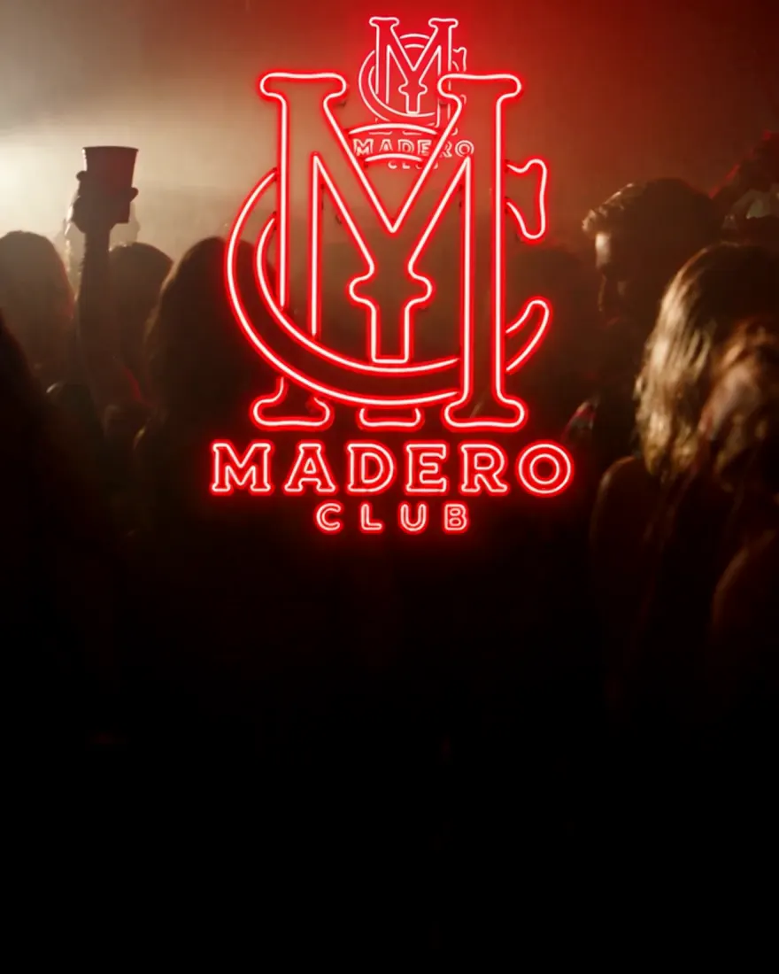 El letrero de neón de Madero Club sobre la gente